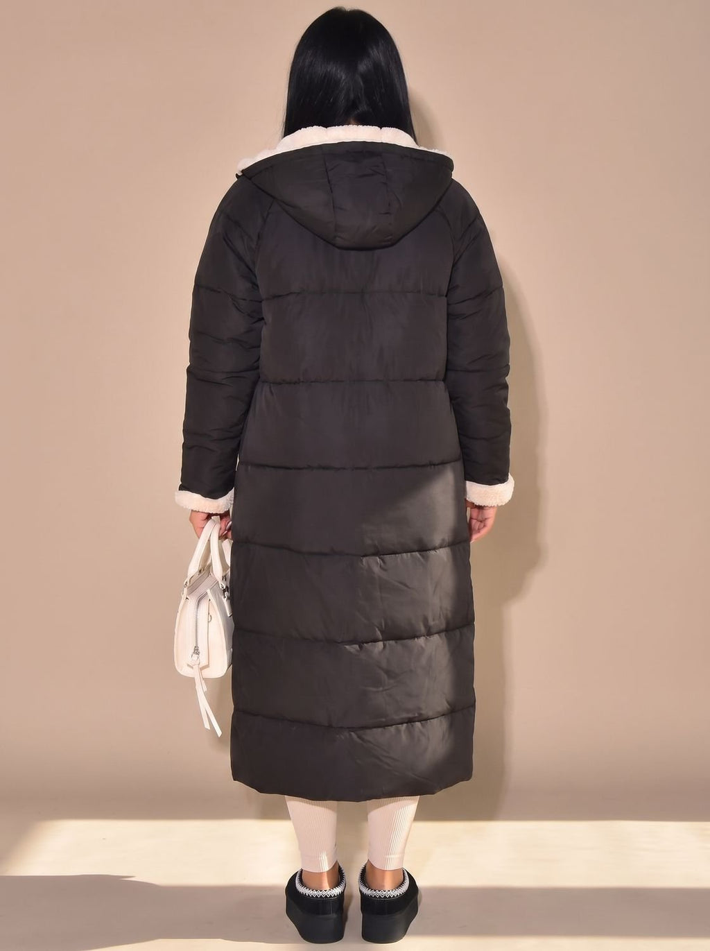 Abrigo reversible mostrando el lado acolchado y el lado sherpa juntos